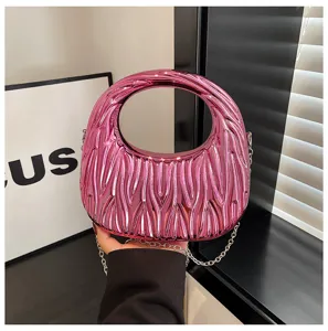 Close-up of a fuchsia metallic textured acrylic handbag featuring a silver chain strap