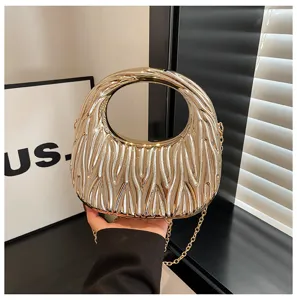 Elegant gold metallic handbag with textured wave pattern and circular handle.