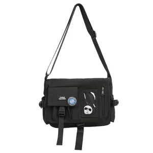 Close-up of black nylon messenger bag with utility pockets and streetwear patches