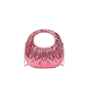 Close-up detail of a pink glossy acrylic handbag featuring a pleated texture and chain strap.