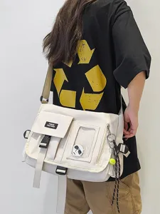 Stylish cream nylon messenger bag worn by a person for casual, school or travel use