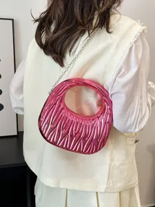 Fashionable metallic pink acrylic handbag with textured pattern and silver chain strap