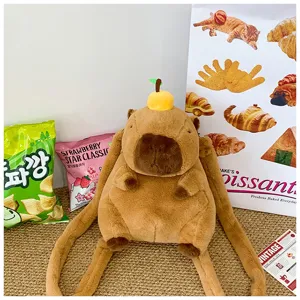Lifestyle shot of a cute cartoon capybara plush backpack surrounded by snack props