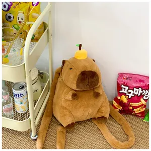 Close-up of cute plush capybara backpack with orange accessory in lifestyle setting.