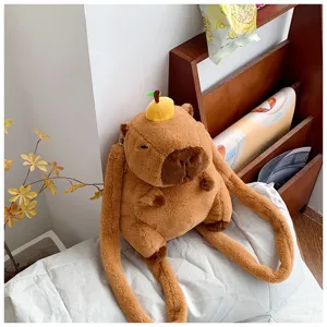 Detail view of the soft brown plush capybara backpack with orange head decor