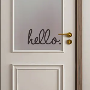 Primo piano dell'adesivo murale 'hello.' minimalista su una finestra della porta.
