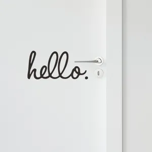 Primo piano dell'adesivo murale rimovibile nero 'hello' su una porta bianca moderna