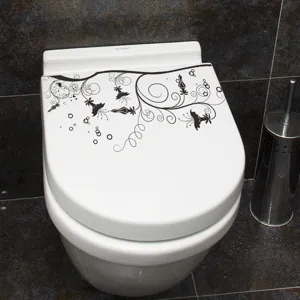 Détail d'un autocollant floral noir appliqué sur un abattant de WC blanc décoratif
