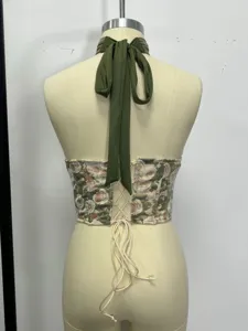 Detailed view of floral corset back design, featuring laced closure and elegant halter neck straps.