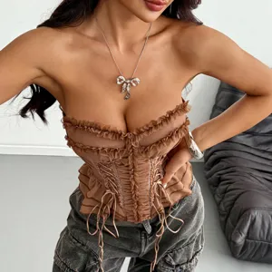 Primo piano di dettaglio del top corsetto marrone con volant, allacciatura frontale e stecche.