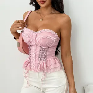 Dettaglio del top corset rosa senza spalline con volant delicati e allacciatura frontale.
