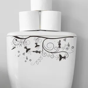 Autocollant floral noir appliqué sur un réservoir de WC blanc pour décoration salle de bain