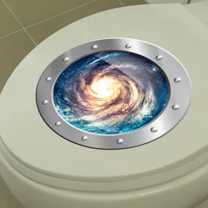 Détail d'un autocollant de couvercle de toilette galaxie dans une salle de bain.