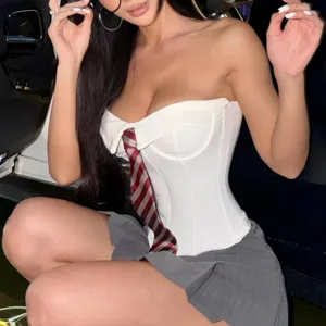 Detail view of the white strapless corset top featuring an attached striped tie and chic design.