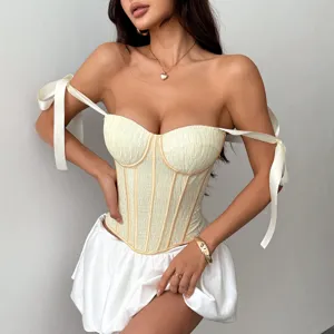Vue détaillée du haut corset crème avec bretelles nœud, baleines de soutien et style épaules dénudées.