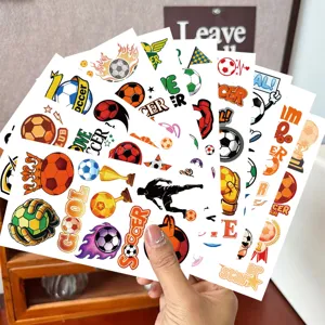 Hand holding a variety of colorful luminous soccer-themed temporary tattoo stickers