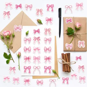 Variety of pink bow stickers applied to kraft envelopes and a gift box in a creative setup