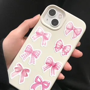 Detailed close-up showing pink bow stickers applied on a cream-colored phone case
