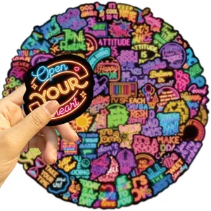 Close-up of a vibrant neon style Open YOUR heart motivational sticker held in a hand