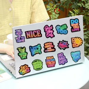 Detail view of colorful neon-style motivational stickers on a laptop lid