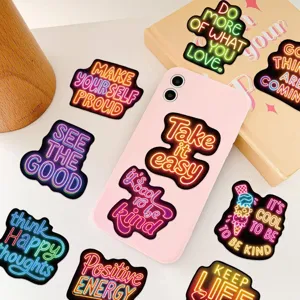 Detailed view of neon-style inspirational English graffiti stickers on pink phone case