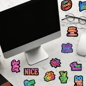 Macro view of colorful neon inspirational quote stickers for laptops and DIY decor.