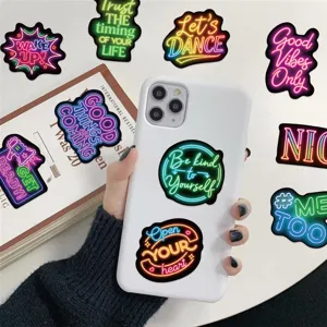 Close-up of waterproof neon inspirational quote stickers applied on a white smartphone