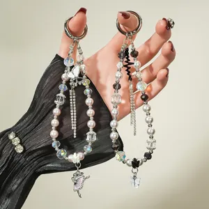 Détail exquis de bijoux de téléphone perlés avec ballerine et pendentifs papillons