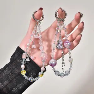 Detailed view of beaded phone charms with iridescent beads and denim guitar pendant