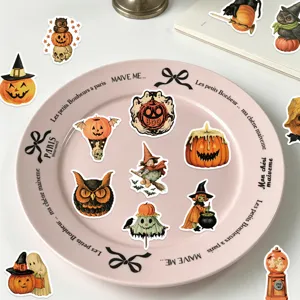 Collection of vintage Halloween pumpkin and owl stickers arranged on a pink plate