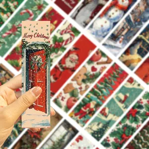 Hand hält vintage weihnachtliches Lesezeichen aus Papier mit festlichem Motiv