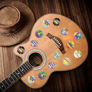 Diverse motiverende ronde stickers met positieve boodschappen op een houten gitaar geplakt