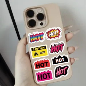 Close-up detail of vibrant HOT and CAUTION themed stickers applied on a beige mobile phone case