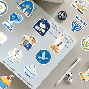 Vista detallada de pegatinas de Hanukkah en un cuaderno de cuadrícula con bolígrafo.