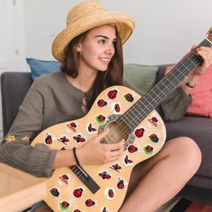 Close-up of cute cartoon ladybug stickers applied to a wooden guitar for DIY decoration