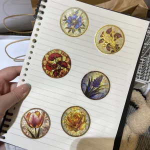 Vue détaillée d'autocollants floraux ronds avec un design en vitrail sur un carnet