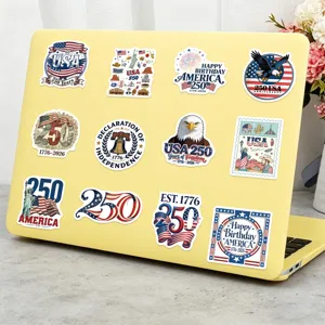 Detailed view of patriotic USA 250th anniversary vinyl stickers on a yellow laptop