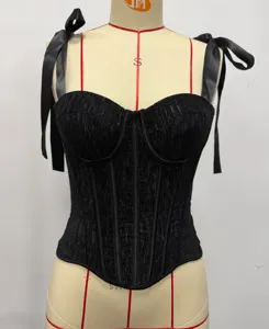 Top corset noir froncé avec bretelles ruban élégantes et baleines de soutien structurées.