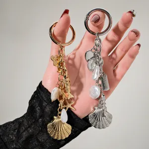 Detailed view of gold and silver marine-themed keychains with shell and pearl charms