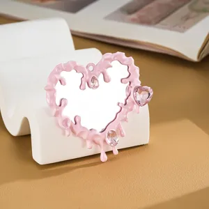 Primo piano dell'accessorio specchio a cuore fluido rosa con cristalli rosa