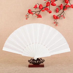 Classic white folding fan with plastic frame and fabric surface displayed on a wooden stand.