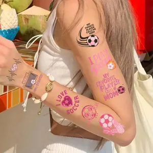 Nahaufnahme von rosa Fußball-Themen-Tattoo-Aufklebern auf dem Arm eines Mädchens