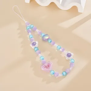 Macro detail of handmade pastel beaded phone strap featuring heart and flower charms