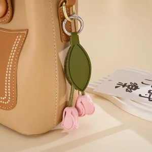Dettaglio ravvicinato di un ciondolo per borsa a forma di tulipano in pelle rosa a mano.