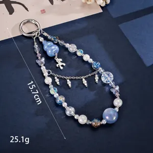 Macro detail of luxury cat's eye beaded phone charm with horse and gourd pendants
