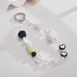 Detalle de un lindo colgante para móvil de cuentas con motivos de caja de regalo y conejo.