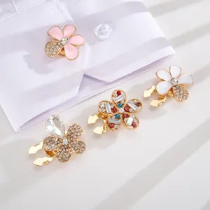 Detailed close-up view of colorful rhinestone flower collar pins on white fabric