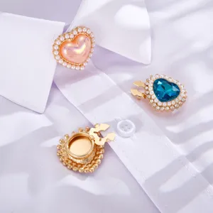 Dettaglio di clip per camicia in perle e pietre a forma di cuore su un colletto bianco