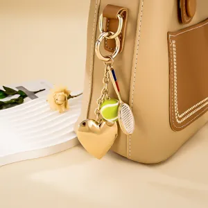 Detailaufnahme eines Tennis-Taschenanhängers mit goldenem Herz und Mini-Schläger