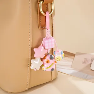 Gros plan d'un porte-clés loutre rose avec des breloques étoiles sur un sac